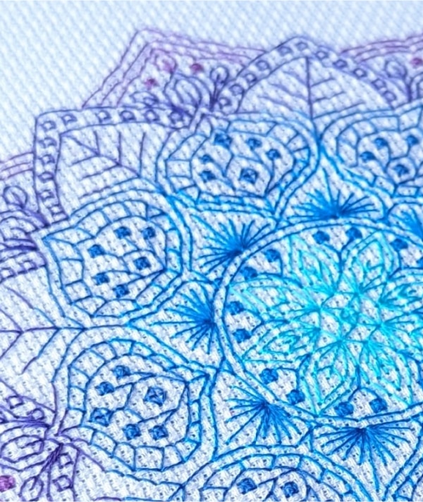Close up of stitched blue and purple mandala pattern